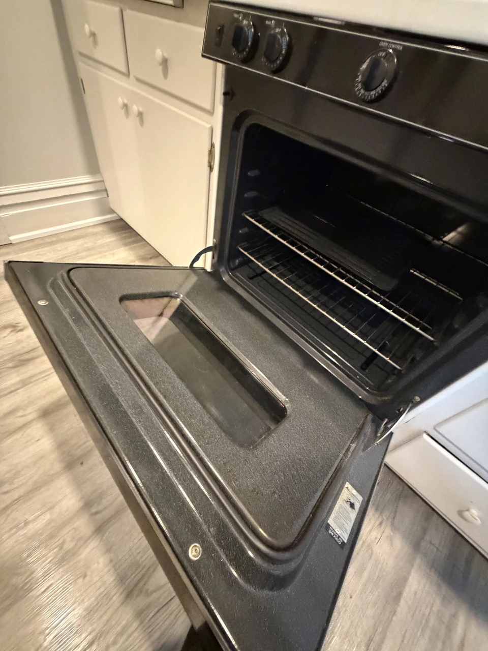An open oven with racks and its door visible